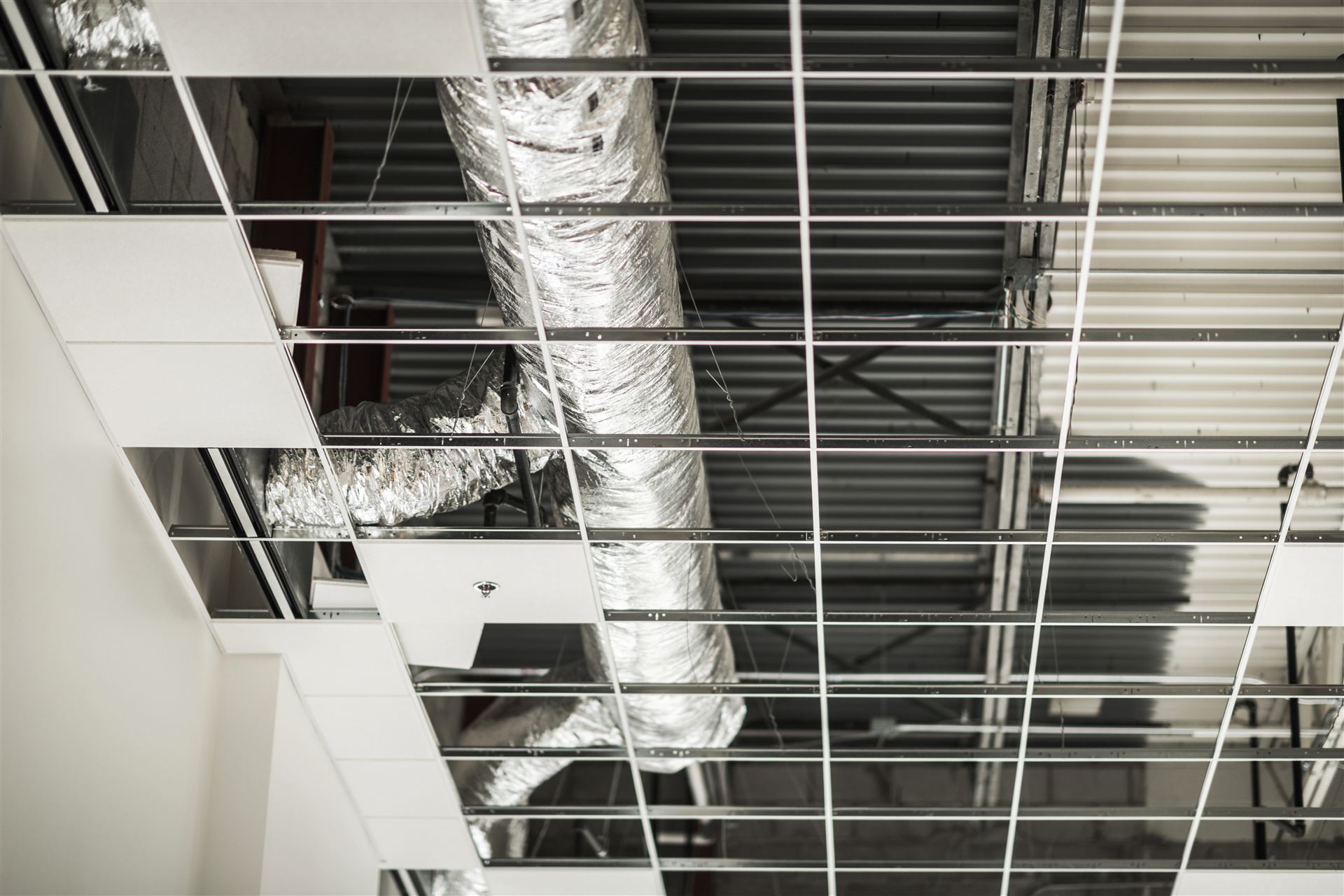 Commercial HVAC ductwork installed in a ceiling grid