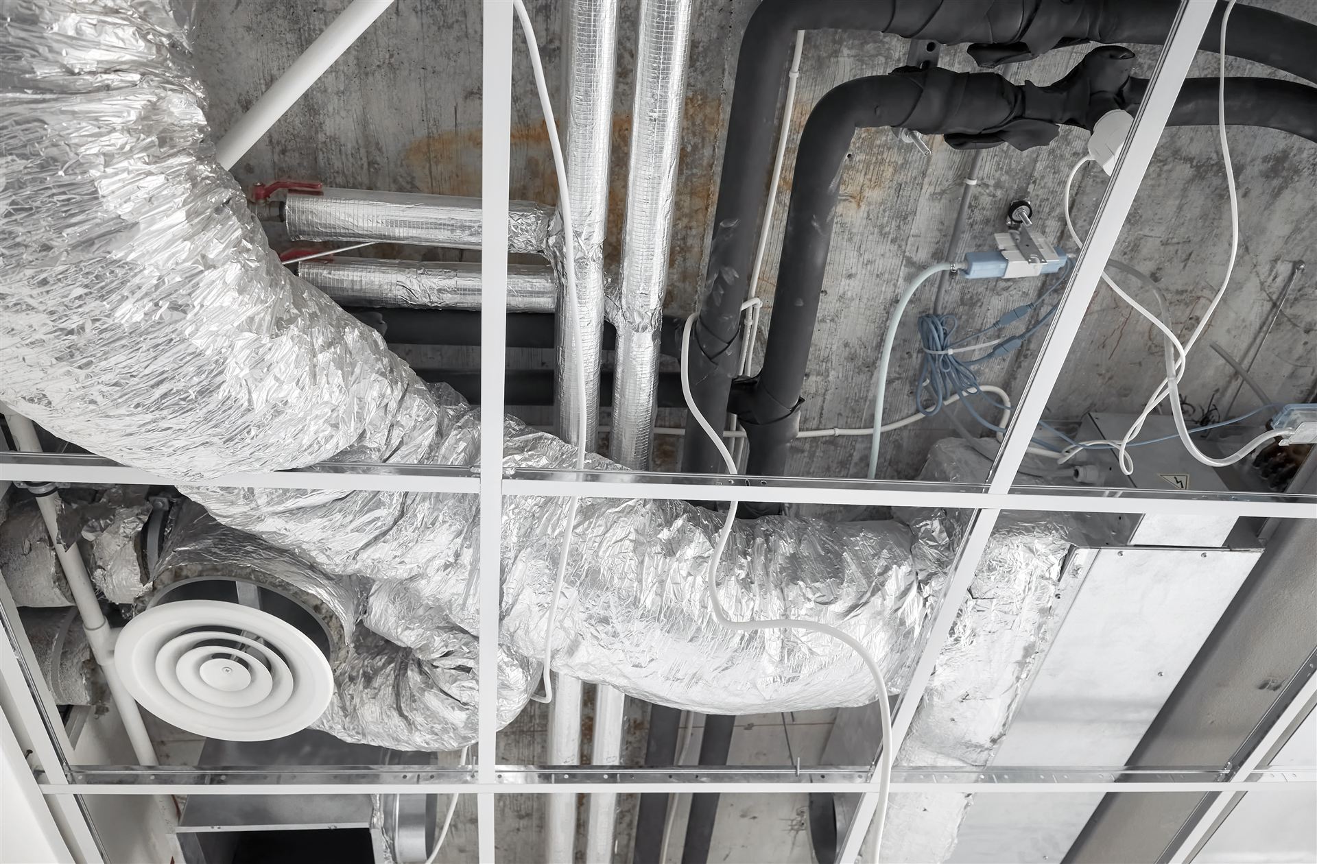 Insulated HVAC ductwork installed above a ceiling